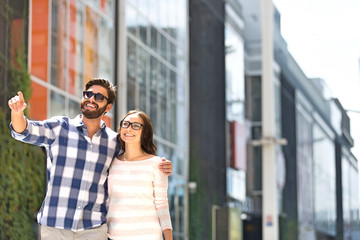 Fototapeta premium Happy man showing something to woman outside building