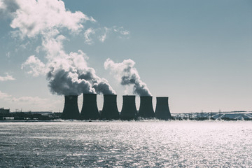 Cooling towers of NPP or Nuclear Power Plant with thick smoke. Dark toned image.