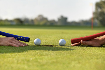 Human hands using golf balls to play pool