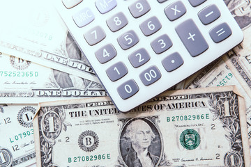 Fototapeta premium Calculator with american dollars on the wooden table background, finance concept