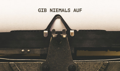 Gib niemals auf, German text for Never Give Up on vintage type writer from 1920s