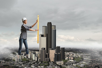 Builder woman taking measures . Mixed media