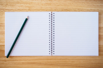 notebook top view with pencil on brown wood desk