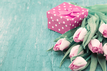 Bouquet of Tulips and gift box on turquoise rustic wooden background with copy space for message. Spring flowers. Greeting card for Valentine's Day, Woman's Day and Mother's Day holidays. Soft focus.