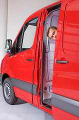 Young man peeking through van door