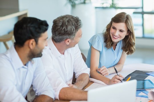 Architects discussing with each other in office