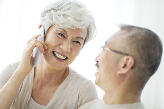 Mature woman using mobile phone, smiling, close up