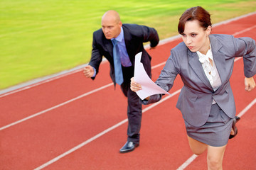Fototapeta premium Businessman and woman on running on race track