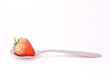 Strawberry on spoon isolated white background
