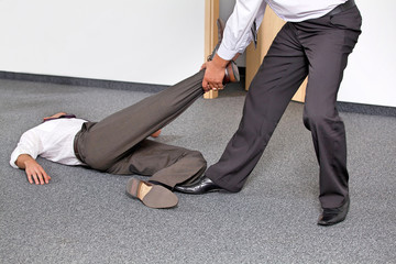 Businessmen pulling colleague's leg at office
