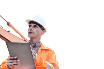 Supervisor looking away while holding clipboard against clear sky