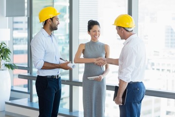 Smiling architects shaking hands with each other