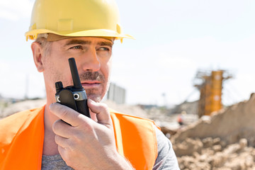 Confident supervisor using walkie-talkie at construction site