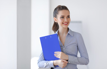 Happy business woman with clipboard in the office