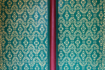 gold pianting flower pattern on green color background, traditional Thai style painted, temple door