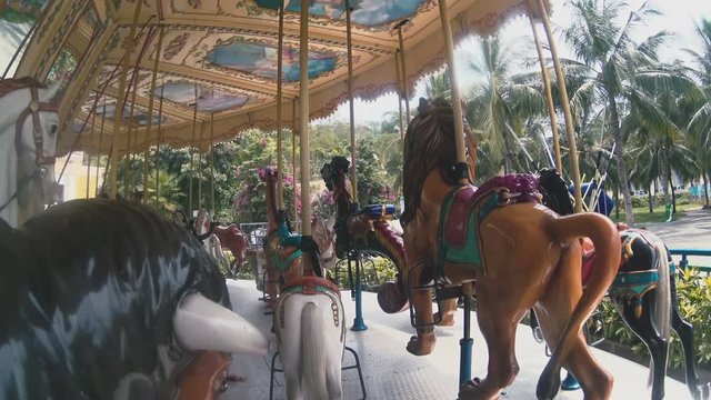 People rides on the carousel in the park