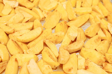 Raw potatoes slices on a baking sheet