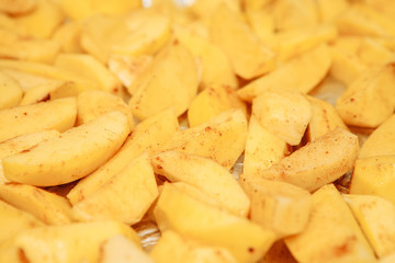 Raw potatoes slices on a baking sheet