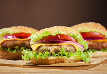 Fresh burgers on wooden background