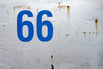 blaue zahl 66 auf metallwand lackiert
