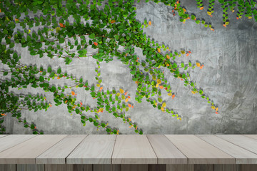 Wooden table with concrete wall and ornamental plants or ivy or garden tree for background.