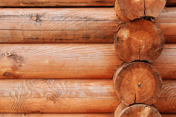 The wall of a wooden house made of solid unrefined timber.