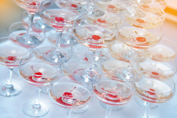 A pyramid of champagne glasses with a cherry