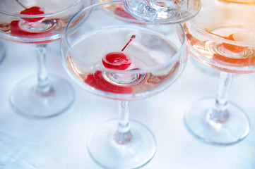 A pyramid of champagne glasses with a cherry