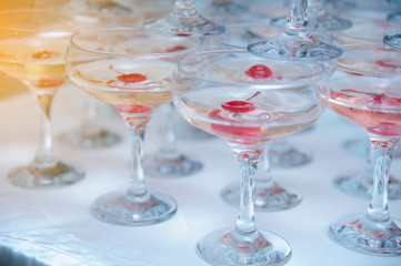 A pyramid of champagne glasses with a cherry