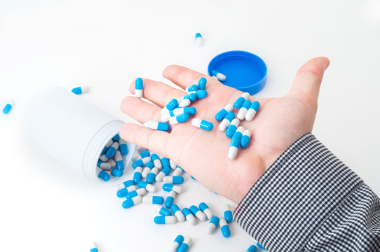 Few blue medical drug pills in hand of man