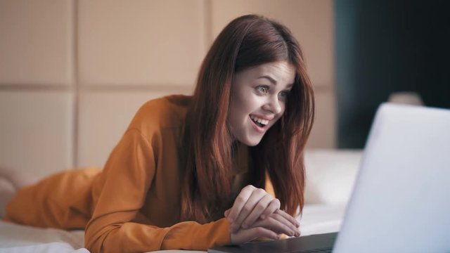 Woman with laptop on the bed
