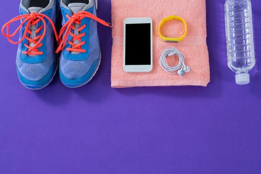 Sneakers, water , towel, phone with headphones