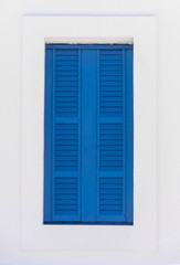 Window with blue shutters on a white wall