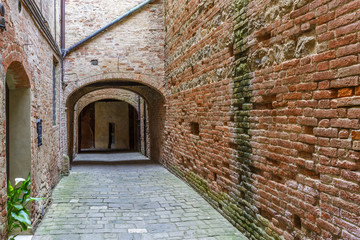 Alley with brick walls in an old village