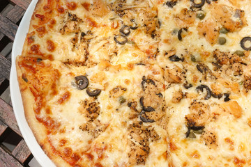 Homemade Tuna Pizza (with black pepper and black olive) on wooden table, top view