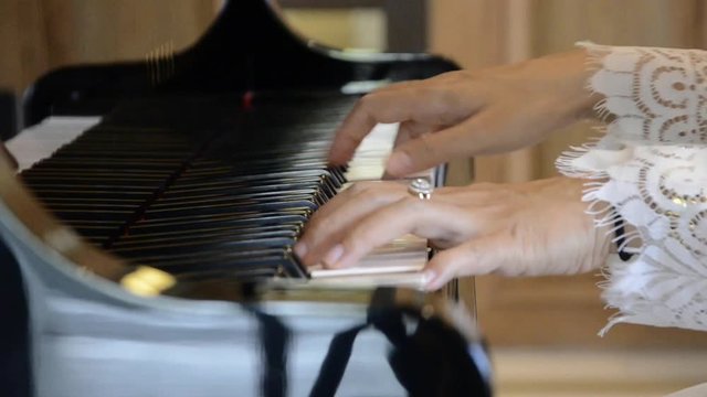 close up of woman musician pianist hands playing piano music 
