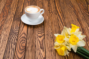 Fototapeta na wymiar Fresh spring yellow daffodils flowers and empty tag on brown painted wooden planks.