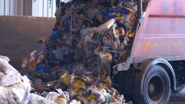 4K. Truck offloading waste into a landfill. 4K