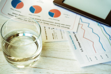 Fototapeta premium Workplace in office, glass of water and schedules