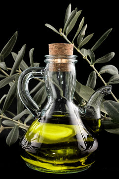A bottle of extra virgin oil with an olive branch as a background