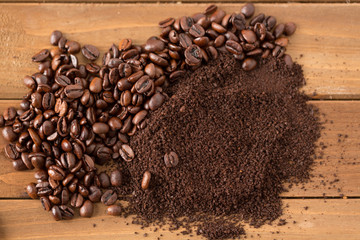 Pile of Coffee Beans and Grounds in Middle of Wood. pile of coffee beans and grounds from above split down the middle above