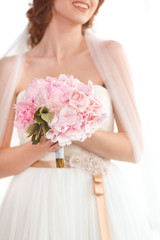 Obraz premium Bridal bouquet of pink wedding flowers in hands of the bride
