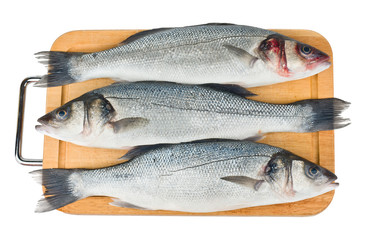 Raw sea bass on a wooden cutting board