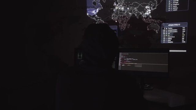 Hacker in hood hacking global network using computers
