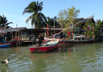 Fototapeta na wymiar A few traditional fishing boats on front of a village, Thailand