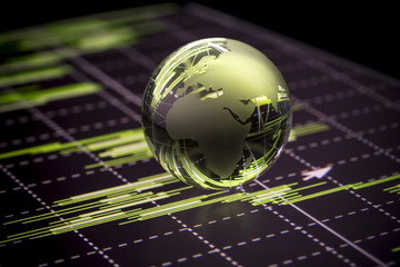Glass globe over stock data on computer screen