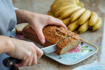 Woman cook cuts banana bread