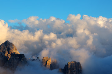 Dolomite Alps, mountain tops in the clouds at sunset