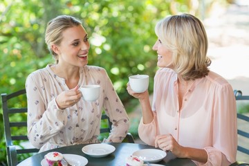Smiling friends enjoying coffee together