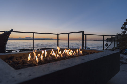 Gas lit backyard fire pit on the beach house outdoor patio at sunset